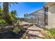 Backyard with stone steps and lush landscaping leading to a screened in porch and private pool at 356 Blackbird Ct, Bradenton, FL 34212