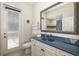 Bright bathroom boasts a navy blue vanity, large mirror, and a door to the outside at 356 Blackbird Ct, Bradenton, FL 34212