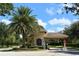 Well-maintained community entrance with a palm tree, tiled roof, and 'STOP' sign at 356 Blackbird Ct, Bradenton, FL 34212