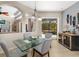Dining area with a view of the screened pool, featuring a glass table and adjacent wine cooler at 356 Blackbird Ct, Bradenton, FL 34212