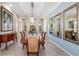 Elegant dining room featuring wood table, decorative mirrors, buffet and chandelier with beautiful archway views at 356 Blackbird Ct, Bradenton, FL 34212