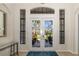 Inviting foyer showcasing elegant glass doors with palm tree accents, sidelight windows, and a view of the front yard at 356 Blackbird Ct, Bradenton, FL 34212