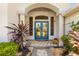 Close-up of front door with tile walkway, stone landscaping, and tropical plants at 356 Blackbird Ct, Bradenton, FL 34212
