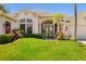 Charming front entrance with tropical landscaping, manicured bushes and blue double door at 356 Blackbird Ct, Bradenton, FL 34212