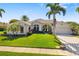 Charming single-story home features a well-manicured lawn, palm trees, and a spacious driveway at 356 Blackbird Ct, Bradenton, FL 34212