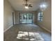 Spacious living room with vaulted ceiling, ceiling fan, pendant light, and sliding doors to the lanai at 3602 Bonaventure Ct, Sarasota, FL 34243