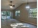 Spacious living room with vaulted ceiling, ceiling fan, pendant light, and sliding doors to the lanai at 3602 Bonaventure Ct, Sarasota, FL 34243