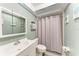 Cozy bathroom featuring a shower with gray curtain and charming beach-themed decorations at 3803 Sun Eagle Ln # 203, Bradenton, FL 34210