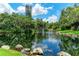 Scenic pond featuring a fountain and surrounded by lush trees creates a serene and picturesque setting at 3803 Sun Eagle Ln # 203, Bradenton, FL 34210