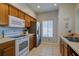 Well-lit kitchen with wood cabinets, stainless steel refrigerator, and white appliances at 3909 45Th W Ter # 102, Bradenton, FL 34210