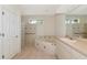 Bright bathroom with a soaking tub, tiled floors, and glass block accent wall at 4092 Green Tree Ave, Sarasota, FL 34233