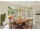 Dining room with set table, chandelier, and large window showcasing outdoor view at 4092 Green Tree Ave, Sarasota, FL 34233