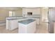 Open kitchen with white cabinets, central island, and breakfast bar with tiled floors at 4092 Green Tree Ave, Sarasota, FL 34233