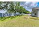 Large backyard with a well-maintained lawn, a stone fire pit, and mature trees at 4513 Abacos Pl, Bradenton, FL 34203