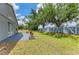 Spacious backyard with mature trees, block fence, and a view of the home's exterior at 4513 Abacos Pl, Bradenton, FL 34203