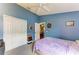 Bedroom featuring blue walls, closet with louvered doors, and a ceiling fan at 4513 Abacos Pl, Bradenton, FL 34203