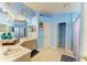 Bright blue bathroom featuring double sinks, ample vanity space, and tile flooring at 4513 Abacos Pl, Bradenton, FL 34203