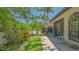 Serene backyard featuring a stone patio, vibrant greenery, and comfortable seating at 4691 Las Brisas Ln, Sarasota, FL 34238