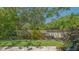 Lush backyard featuring a mix of tropical plants, green grass, and privacy fencing at 4691 Las Brisas Ln, Sarasota, FL 34238