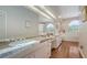 Bright bathroom featuring double sinks, granite countertops, a large mirror, and elegant hardwood floors at 4691 Las Brisas Ln, Sarasota, FL 34238