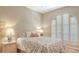 Inviting bedroom with shuttered window, patterned bedding, bedside table, and soft lighting at 4691 Las Brisas Ln, Sarasota, FL 34238