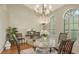 Elegant dining room featuring hardwood flooring, round glass table, and plantation shutters at 4691 Las Brisas Ln, Sarasota, FL 34238