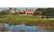 Exterior shot of golf course clubhouse overlooking a pond, and golf cart approaching at 4691 Las Brisas Ln, Sarasota, FL 34238