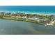Breathtaking aerial view of beachfront property with marina, showcasing pristine sands and tranquil waters at 4800 Gulf Of Mexico Dr # 205, Longboat Key, FL 34228