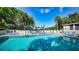 Sparkling community pool with lounge chairs, clear skies, and well maintained landscape at 4800 Gulf Of Mexico Dr # 205, Longboat Key, FL 34228