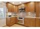 Eat-in kitchen boasting stainless steel appliances, natural wood cabinets, mosaic backsplash, and tons of storage at 4800 Gulf Of Mexico Dr # 205, Longboat Key, FL 34228
