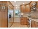 Updated eat-in kitchen showcases stainless appliances, natural wood cabinets, stylish backsplash, and a view of the window at 4800 Gulf Of Mexico Dr # 205, Longboat Key, FL 34228