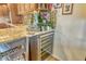 Gourmet kitchen with wood cabinetry, granite countertops, a wine fridge, and tile backsplash create an inviting culinary space at 4800 Gulf Of Mexico Dr # 205, Longboat Key, FL 34228