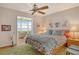 Bright bedroom with colorful bedding, ceiling fan, water view, and a comfortable seating area at 4800 Gulf Of Mexico Dr # 205, Longboat Key, FL 34228