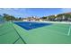 Outdoor tennis courts with views of nearby condos, landscaping, and a blue sky at 4800 Gulf Of Mexico Dr # 205, Longboat Key, FL 34228