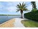 Scenic waterfront view with a palm tree and bench, perfect for relaxing and enjoying the beautiful scenery at 4800 Gulf Of Mexico Dr # 205, Longboat Key, FL 34228