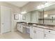 Elegant bathroom with double sinks, granite countertops, and decorative mirrors at 4908 Tivoli Run, Bradenton, FL 34211