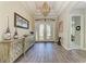 Elegant foyer with hardwood floors, decorative console table, chandelier, and a view of the ornate front door at 4908 Tivoli Run, Bradenton, FL 34211