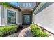 Elegant front entrance with glass double doors, stone accents, and lush landscaping at 4908 Tivoli Run, Bradenton, FL 34211