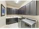Well-equipped laundry room with dark cabinets, washer, dryer, a sink and countertops at 4908 Tivoli Run, Bradenton, FL 34211