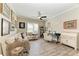 Cozy room with wood floors, decorated with a fan, white sofa and many paintings at 4908 Tivoli Run, Bradenton, FL 34211