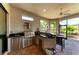 Well equipped outdoor kitchen with stainless steel grill and bar overlooking tropical backyard at 4908 Tivoli Run, Bradenton, FL 34211