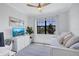 Bright bedroom with a daybed, ceiling fan, and a large window overlooking the landscaped outdoors at 4975 Seafoam Trl, Bradenton, FL 34211