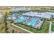 Overhead shot of a community pool area featuring lounging spots, splash pads, and tennis courts at 4975 Seafoam Trl, Bradenton, FL 34211
