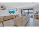 Open living space with a large sofa, entertainment center, and sliding glass doors to the pool area at 4975 Seafoam Trl, Bradenton, FL 34211