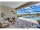 Covered patio with comfortable seating overlooking a gorgeous pool and tranquil lake view at 4975 Seafoam Trl, Bradenton, FL 34211
