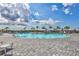 View of the community pool with a clear blue sky, many chairs and tables for residents to enjoy at 4975 Seafoam Trl, Bradenton, FL 34211