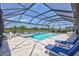 Relaxing pool area with lounge chairs and a view of the pond in a screened enclosure at 4975 Seafoam Trl, Bradenton, FL 34211