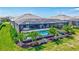 A screened-in pool is surrounded by lush landscaping and an outdoor dining area at 4975 Seafoam Trl, Bradenton, FL 34211
