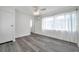 Cozy bedroom featuring gray wood-look floors, a window with curtain, closet, and a ceiling fan at 5214 11Th S Ave, Gulfport, FL 33707