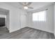 Clean bedroom with a ceiling fan, closet, a window with curtains, and gray wood-look floors at 5214 11Th S Ave, Gulfport, FL 33707